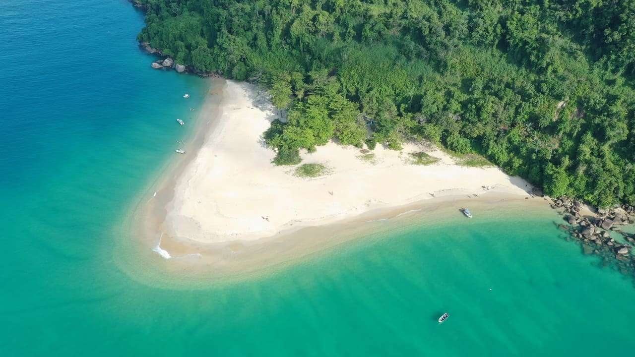 Vista aérea da Ilha do Prumirim, com faixa de areia clara e mar verde-esmeralda